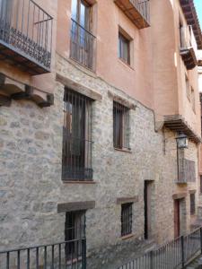 an old brick building with windows and a fence at CASA CENTRO ALBARRACIN in Albarracín