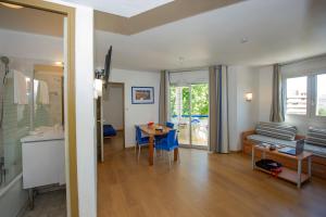 a living room with a table and a dining room at Appart'hôtel Goélia Sun City in Montpellier