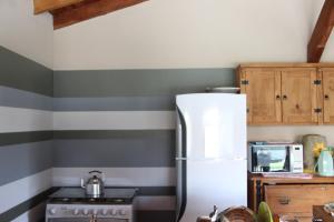 a kitchen with gray and white striped walls and a refrigerator at Casa para temporada com 3 suítes com ar condicionado in Bonito