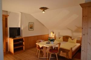 1 dormitorio con cama, mesa y TV en Gästehaus Maria, en Garmisch-Partenkirchen