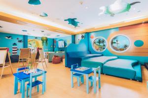 a childrens room with a blue couch and tables at Iberostar Selection Cancun in Cancún