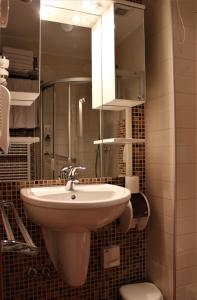 a bathroom with a sink and a mirror and a toilet at Apartman 304 - Aparthotel Vucko in Jahorina