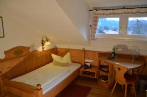 a bedroom with a bed and a desk and a window at Gästehaus Maria in Garmisch-Partenkirchen
