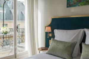 a bedroom with a bed and a balcony at Hôtel Alfred Sommier in Paris