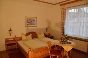 Schlafzimmer mit einem Bett, einem Tisch und einem Fenster in der Unterkunft Gästehaus Maria in Garmisch-Partenkirchen