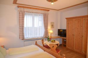 een slaapkamer met een bed, een tafel en een televisie bij Gästehaus Maria in Garmisch-Partenkirchen
