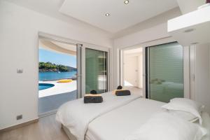 a bedroom with a bed and a view of the ocean at Villa Soleil in Vela Luka