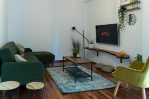 a living room with two green chairs and a tv at A10 SecretHouse in Athens