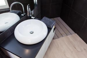 a bathroom with a white sink on a black counter at Villa Soleil in Vela Luka