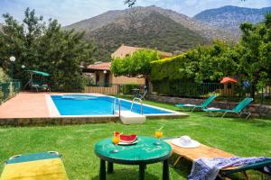 a backyard with a pool and a table with fruit on it at Villa Apelia - Family Holidays Deals in Vlikhádha
