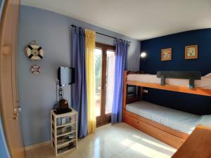 1 Schlafzimmer mit 2 Etagenbetten und einem TV in der Unterkunft Holiday Tossa Apartment in Tossa de Mar