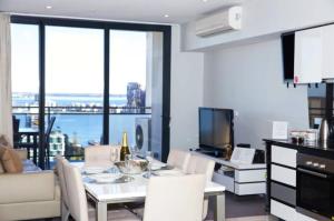 a kitchen and living room with a table and chairs at CENTRAL CBD EXEC STUNNING VIEW WIFI NETFLIX WINE in Perth