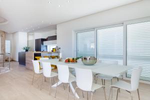 a kitchen and dining room with a white table and chairs at Villa Soleil in Vela Luka