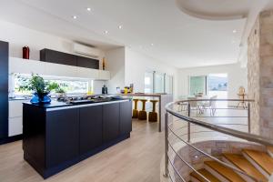 a kitchen with black and white cabinets and a staircase at Villa Soleil in Vela Luka