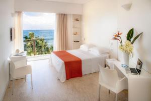 Schlafzimmer mit einem Bett und Meerblick in der Unterkunft Hotel Caravelle Thalasso & Wellness in Diano Marina