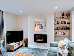 uma sala de estar com um sofá e uma lareira em Sandalwood Apartment - Saltburn by the Sea em Saltburn-by-the-Sea