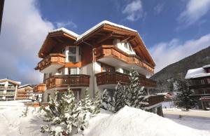 un edificio con nieve delante en Appartements Feehof, en Saas-Fee