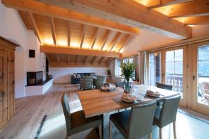 a dining room with a wooden table and chairs at Exklusive Dachwohnung mit herrlicher Aussicht in Klosters