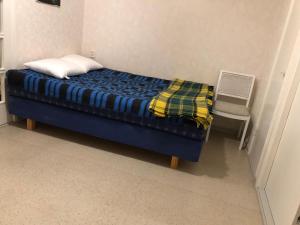 1 dormitorio con 1 cama azul y 1 silla en Kontiomaki, en Kontiomäki