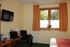 a hotel room with a desk and a window at Landhotel Dresden in Dresden