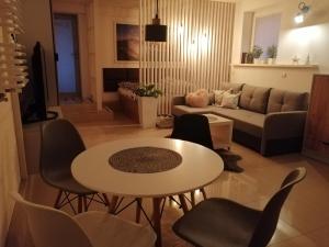 a living room with a couch and a table and chairs at Apartament BeSkidSki in Szczyrk