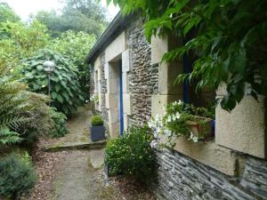 una casa de piedra con plantas a un lado en A L'Ombre Du Figuier, en Saint-Thois
