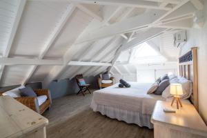 a bedroom with a bed and a chair in a attic at Résidence La Plage Orient Bay by La Conciergerie FWI in Saint Martin