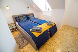 1 dormitorio con 1 cama grande con sábanas y almohadas azules en Apartment A1, en Liubliana
