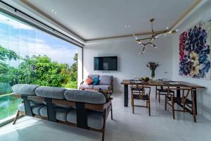 a living room with a couch and a dining table at MIREVA Villas in Haad Pleayleam