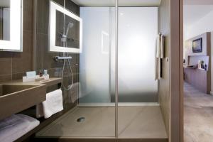 a bathroom with a refrigerator, sink, and mirror at Novotel London Excel in London