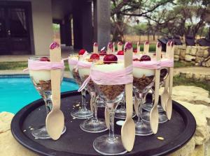 un gruppo di dessert in bicchieri da vino su un vassoio di AFRICAN DREAMS GUESTHOUSE a Okahandja