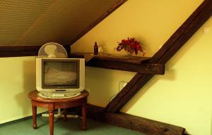 a tv sitting on a table next to a wall at Pensjonat Pałacyk in Łańcut