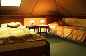 萬楚特的住宿－帕拉基旅館，一间卧室配有两张床和一张带两盏灯的桌子。