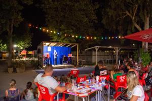 een groep mensen die 's avonds aan tafel zitten op een feestje bij Camping Domaine Du Golfe De Saint Tropez in Grimaud