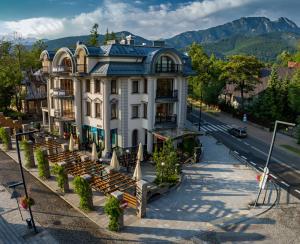 a building with a bunch of benches in front of it at Aparthotel Cristina in Zakopane
