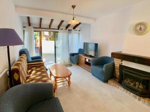 salon z niebieskimi krzesłami i kominkiem w obiekcie Clubrent - Townhouse La Merced w mieście Calpe