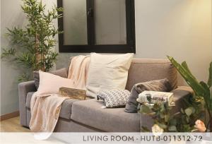 a living room with a gray couch with pillows at Suite Place Barcelona Còrsega in Barcelona