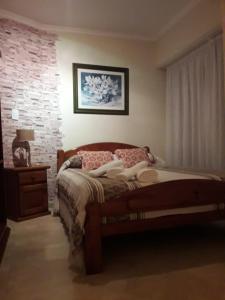 a bedroom with a bed and a brick wall at Depto en La Vicente! in Olavarría