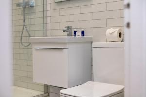 a white bathroom with a sink and a toilet at Cairn Suite - Donnini Apartments in Ayr