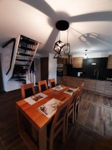uma sala de jantar com uma mesa de madeira e cadeiras em La Maison Trésallet em La Plagne Tarentaise