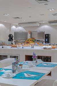 a cafeteria with a table with plates of food at Slaviero Porto Velho in Porto Velho