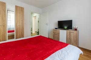 - une chambre avec une couverture rouge sur un lit dans l'établissement Relax Apartment 3, à Sighişoara 2 autres photos