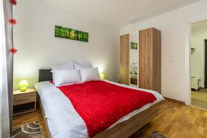 une chambre avec un grand lit recouvert d'une couverture rouge dans l'établissement Relax Apartment 3, à Sighişoara
