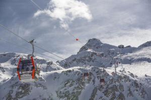 a ski lift going over a snow covered mountain at Snow peak in Ponte di Legno