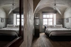 ボルツァーノにあるGoldenstern Townhouseの窓が2つある部屋にベッドが2つある