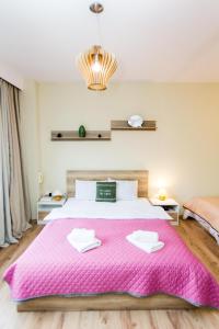 ein Schlafzimmer mit einem großen Bett mit einer rosa Decke in der Unterkunft Central apartment Downtown in Thessaloniki