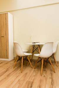 ein Esszimmer mit weißen Stühlen und einem Tisch in der Unterkunft Central apartment Downtown in Thessaloniki