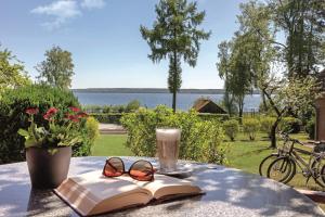 a table with a book and glasses and a drink at Ferienpark Heidenholz in Plau am See
