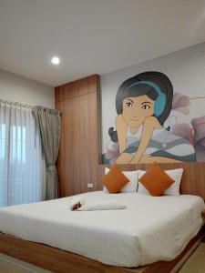 a bedroom with a painting of a woman on the wall at Tairada Boutique Hotel in Krabi