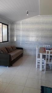 sala de estar con sofá y mesa en Apartamento Ponta das Canas, en Florianópolis